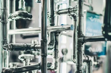 Close-up of complex stainless steel pipes in an industrial setting, showcasing modern engineering.